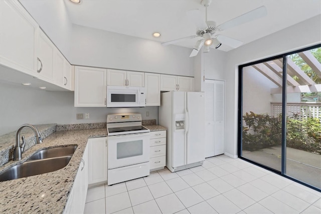 kitchen featuring white appliances, white cabinets, sink, ceiling fan, and light stone countertops