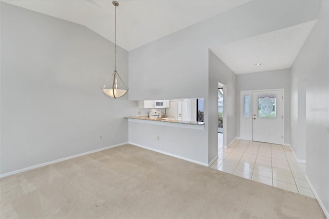 carpeted entryway with sink and vaulted ceiling