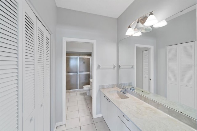 bathroom featuring toilet, vanity, tile patterned floors, and walk in shower