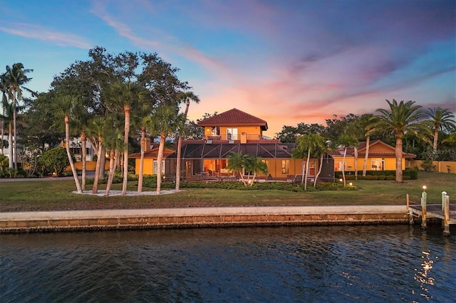 view of jungle gym featuring a lanai, a lawn, and a water view