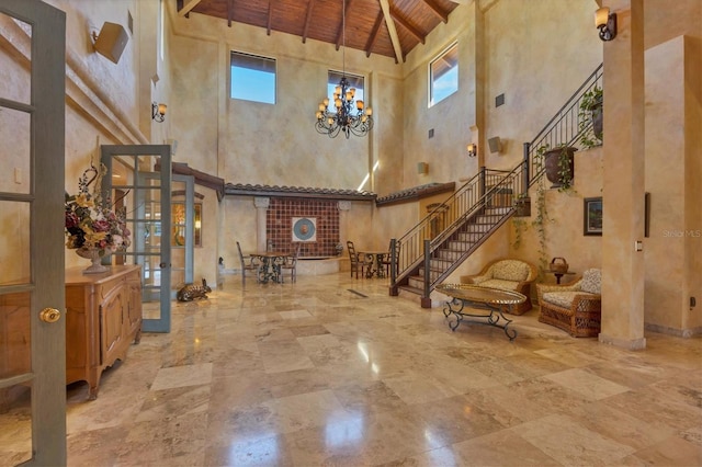 foyer featuring beamed ceiling, stairway, an inviting chandelier, baseboards, and wood ceiling