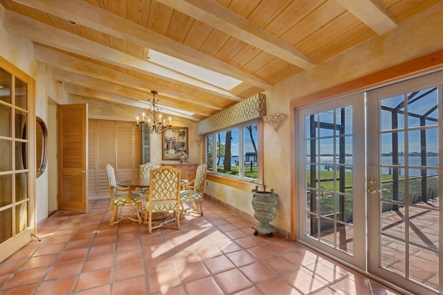 sunroom featuring wooden ceiling, a notable chandelier, and lofted ceiling with skylight