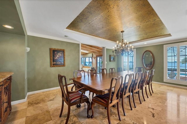 dining space featuring baseboards, a raised ceiling, and a chandelier