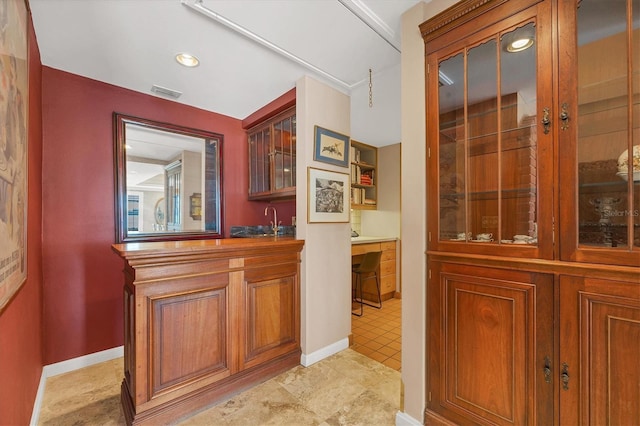 interior space featuring baseboards, visible vents, and a sink