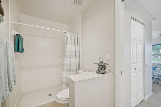 bathroom featuring toilet, a textured ceiling, and a shower with shower curtain