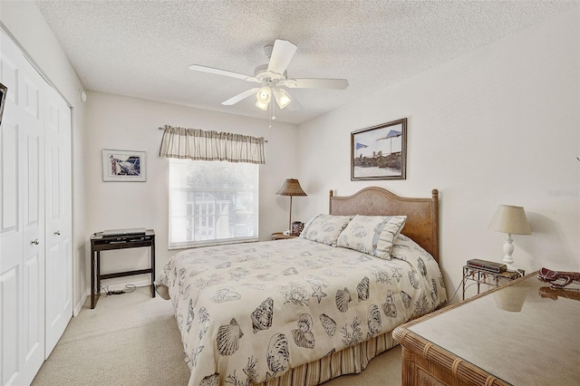 carpeted bedroom with a textured ceiling, a closet, and ceiling fan