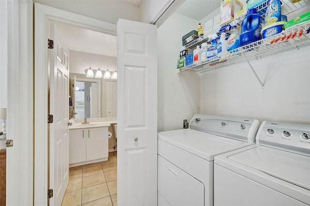 washroom with light tile patterned floors, separate washer and dryer, and sink