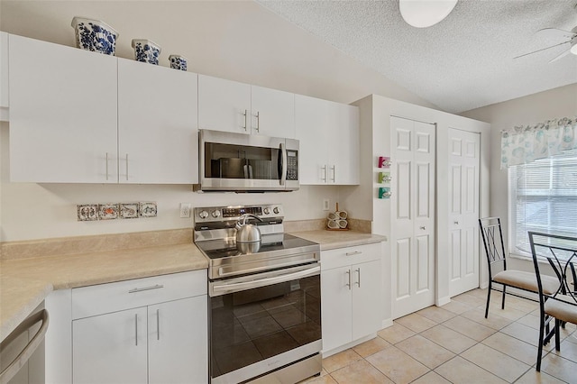 kitchen with white cabinetry, a textured ceiling, and appliances with stainless steel finishes