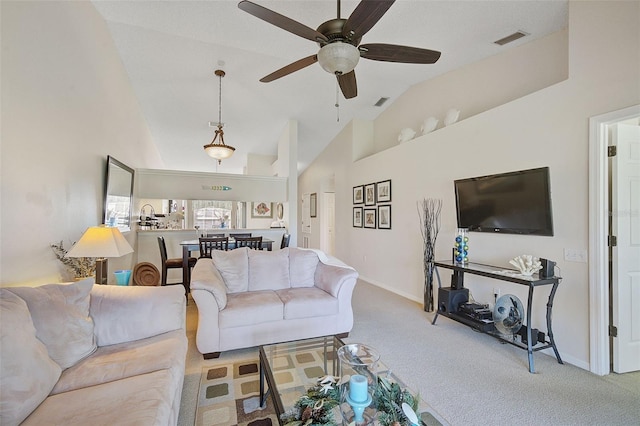 carpeted living room featuring vaulted ceiling and ceiling fan