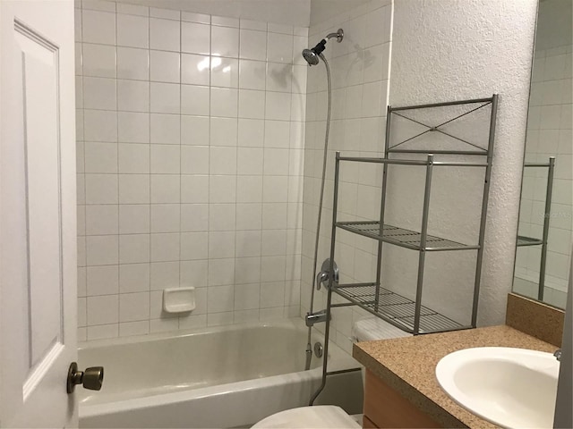 full bathroom with vanity, tiled shower / bath, and toilet