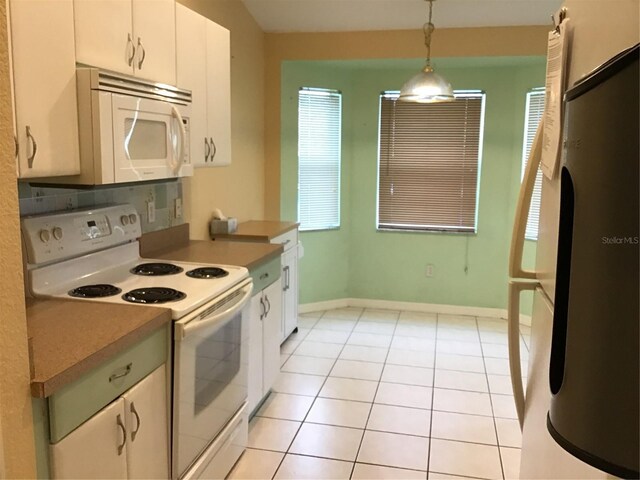 kitchen featuring light tile patterned flooring, white cabinetry, decorative light fixtures, white appliances, and backsplash