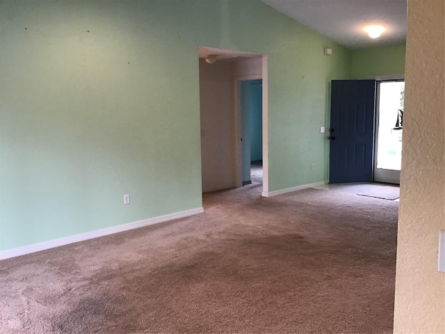 carpeted spare room with lofted ceiling