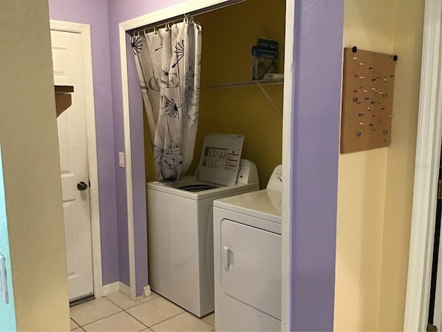 clothes washing area featuring light tile patterned flooring and separate washer and dryer