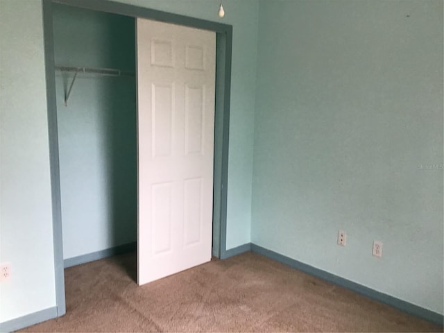 unfurnished bedroom featuring carpet flooring and a closet