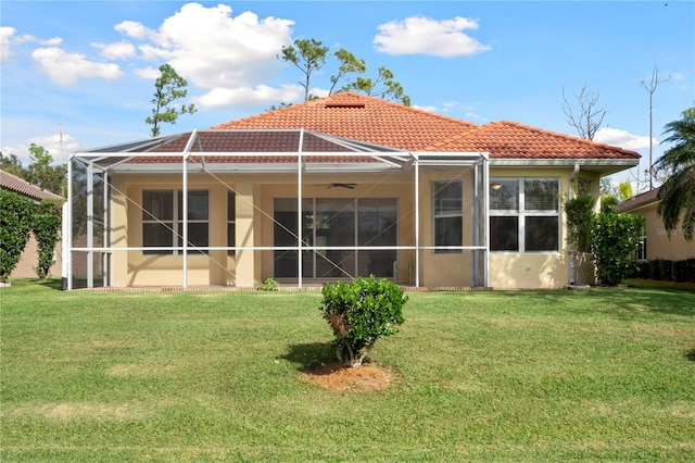 rear view of house featuring a yard and glass enclosure