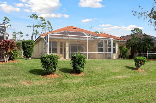 back of house featuring a lanai and a lawn