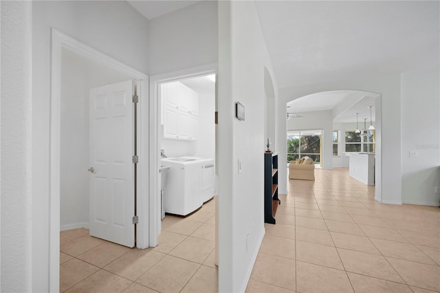 hall featuring light tile patterned floors and washing machine and clothes dryer