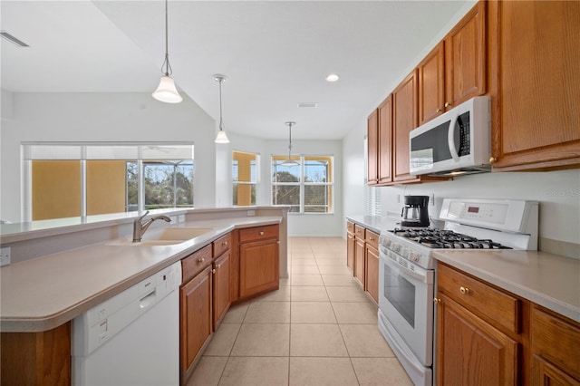 kitchen featuring sink, light tile patterned floors, hanging light fixtures, and white appliances