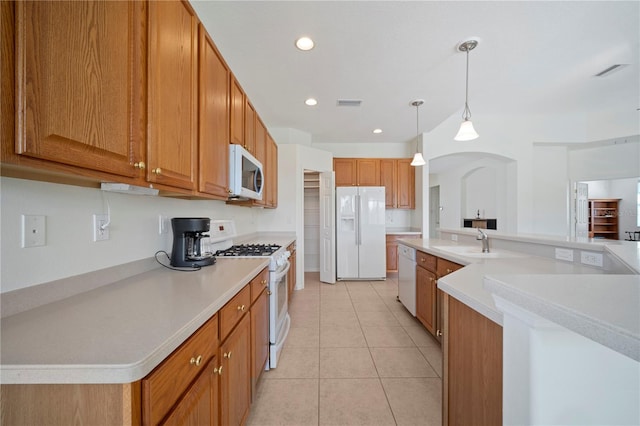 kitchen featuring sink, hanging light fixtures, a large island with sink, white appliances, and light tile patterned floors