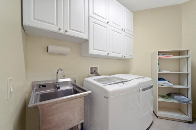 washroom with cabinets, sink, separate washer and dryer, and light tile patterned flooring