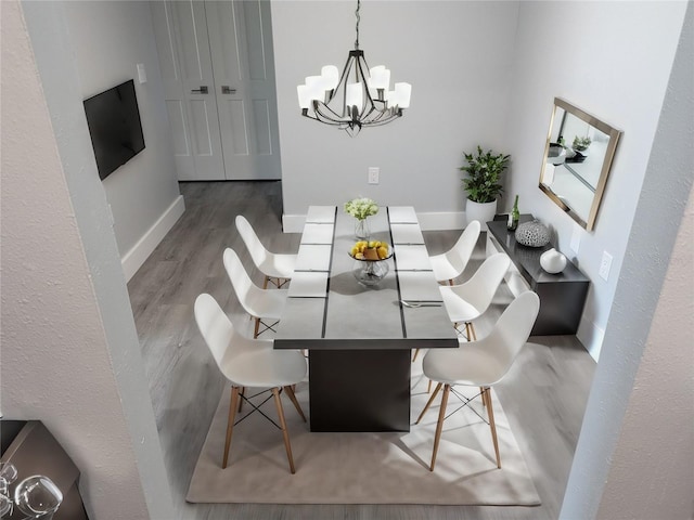 dining space featuring hardwood / wood-style flooring and a notable chandelier