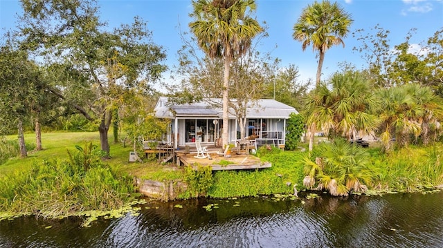 rear view of house featuring a deck with water view