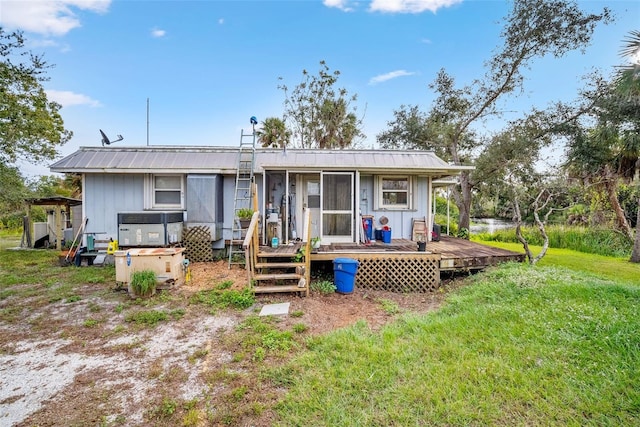 back of house with a deck and a yard