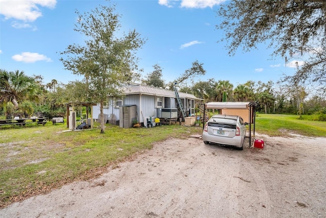 manufactured / mobile home with a carport and a front yard