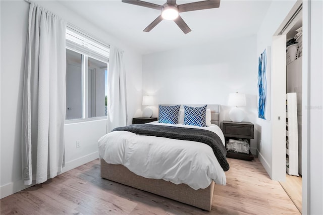 bedroom featuring multiple windows, light hardwood / wood-style floors, and ceiling fan