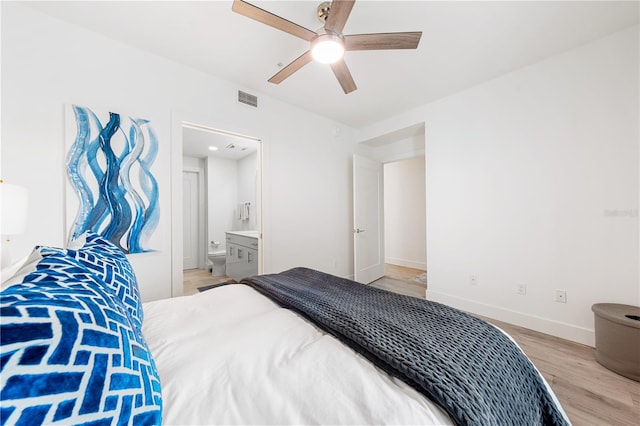 bedroom with light hardwood / wood-style floors, ceiling fan, and ensuite bathroom