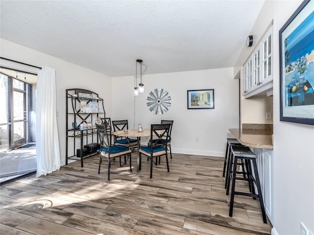 dining space featuring dark hardwood / wood-style floors and a textured ceiling