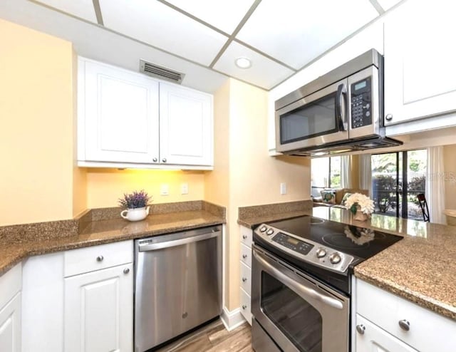 kitchen with white cabinets, recessed lighting, visible vents, stainless steel appliances, and light wood finished floors