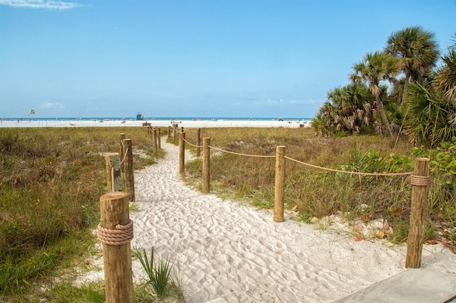 view of property's community with a water view and a beach view