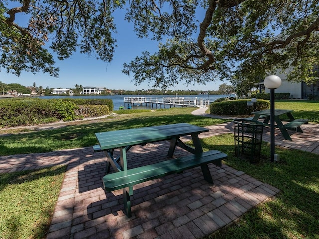 view of home's community featuring a patio, a lawn, and a water view