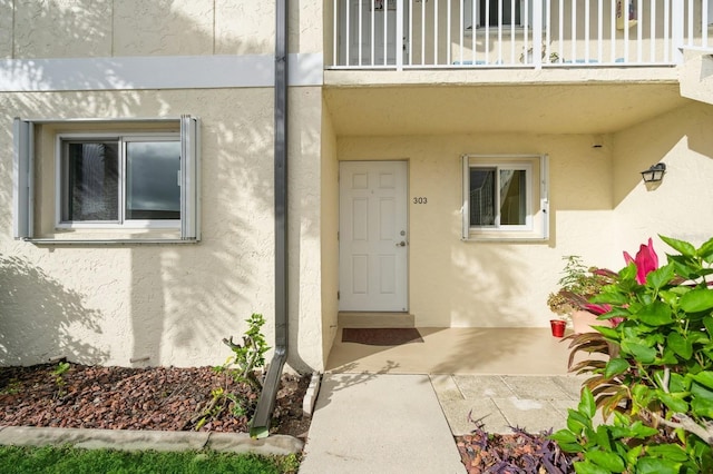 property entrance with a balcony and a patio