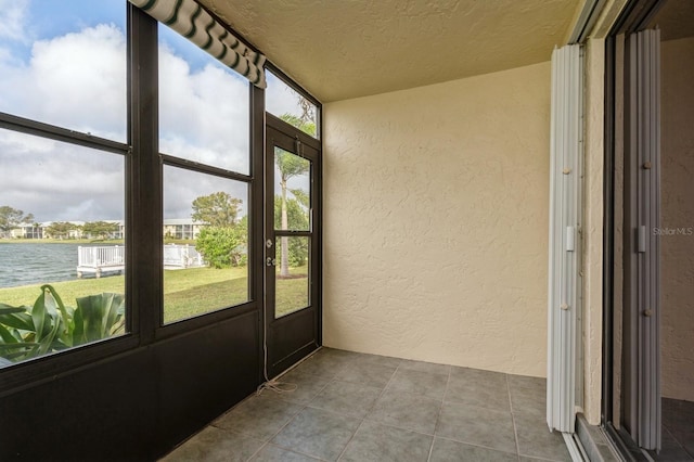 unfurnished sunroom featuring a water view