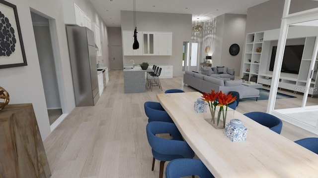 dining area with a towering ceiling and light hardwood / wood-style flooring