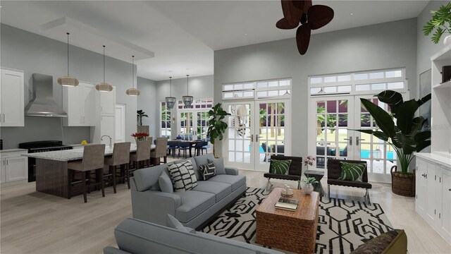 living room with a high ceiling, light hardwood / wood-style floors, french doors, and ceiling fan