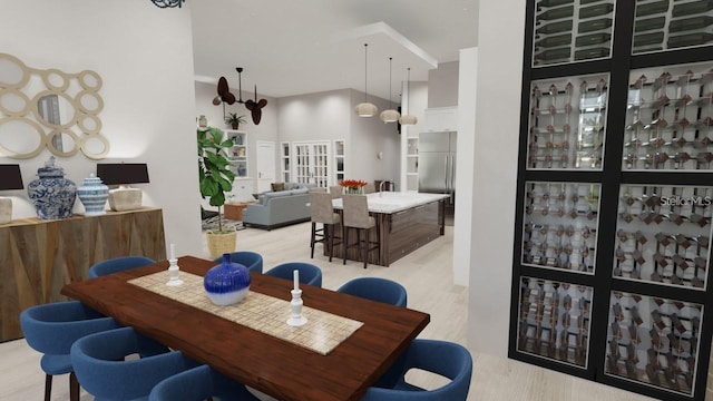 dining space featuring a high ceiling and light hardwood / wood-style floors