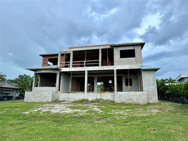 rear view of property featuring a lawn