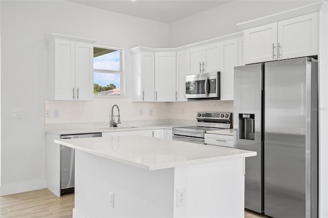 kitchen featuring a kitchen island, stainless steel appliances, and white cabinets