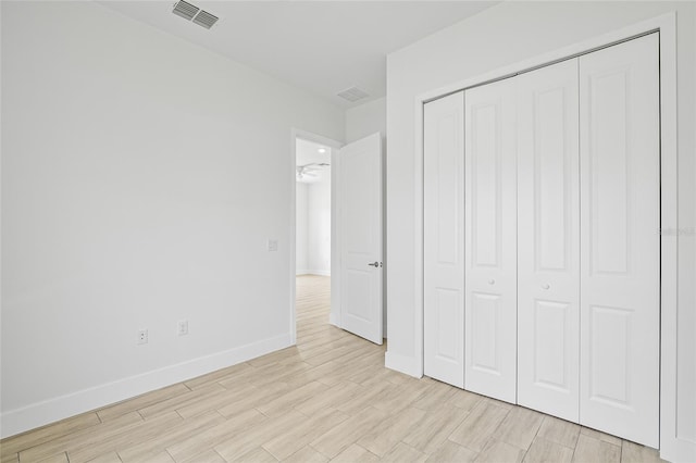 unfurnished bedroom featuring light wood-type flooring and a closet