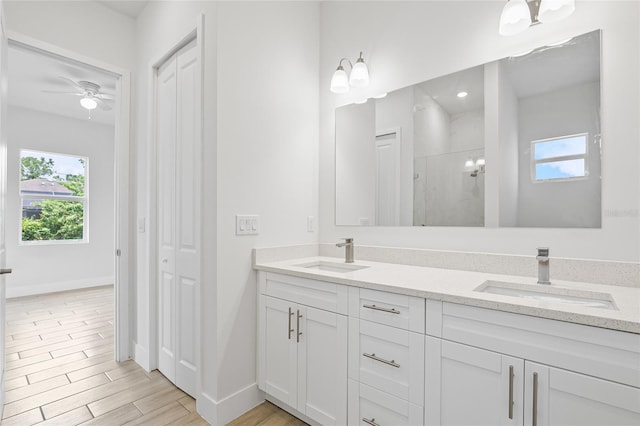 bathroom featuring walk in shower, vanity, hardwood / wood-style floors, and ceiling fan