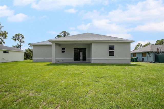 rear view of house with a patio and a yard