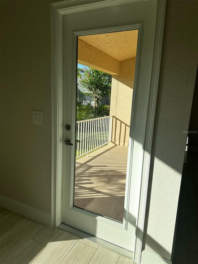 entryway with wood-type flooring and a textured ceiling