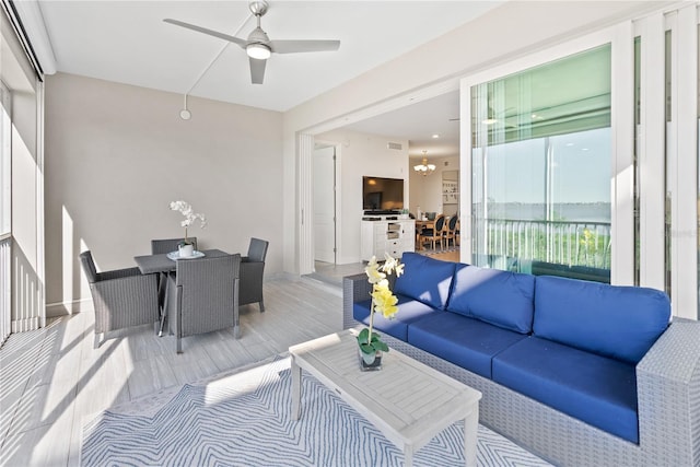 interior space with ceiling fan with notable chandelier