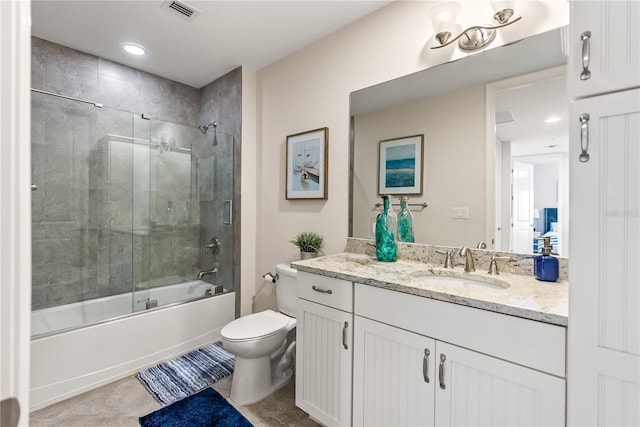 full bathroom featuring tile patterned flooring, vanity, combined bath / shower with glass door, and toilet