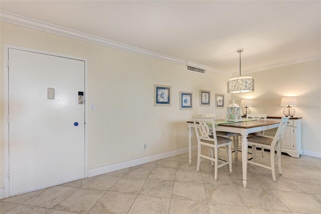 dining space featuring baseboards, visible vents, and crown molding