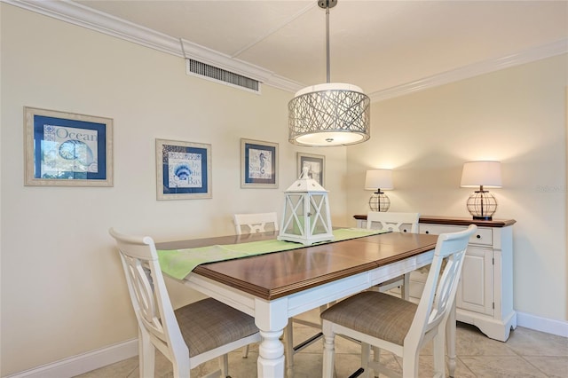 dining space with light tile patterned floors, ornamental molding, visible vents, and baseboards