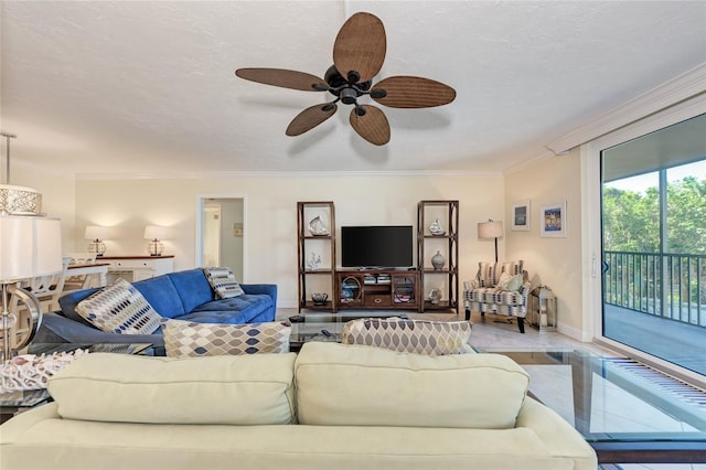 living room featuring ornamental molding, ceiling fan, a textured ceiling, and baseboards